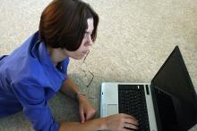 Une jeune femme travaille sur son ordinateur portable.