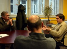 Trois enseignants-chercheurs échangent dans un bureau, autour d'une table ronde.