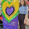Bleona Rugojav pose devant l'affiche des festivités "En Mai, faites l'Europe"