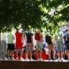 Photo d'une foule vue de dos. Les gens sont debout sur un muret, regardent tous un événement qui se déroule dans la rue devant eux