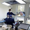 Le praticien-formateur et ses assistants réalisent un soin sur une patiente